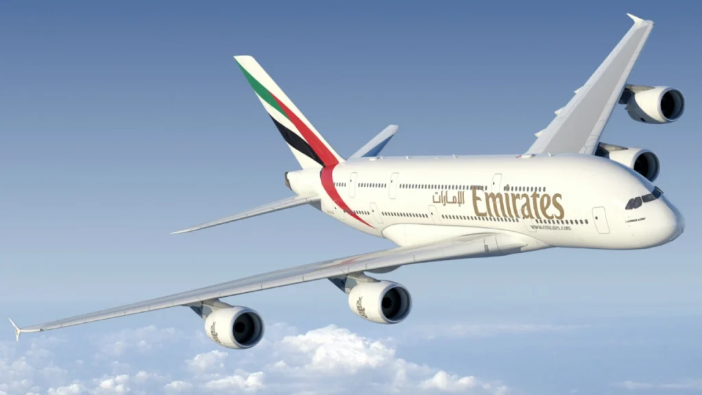 Emirates Airlines aircraft flying high in a clear blue sky.